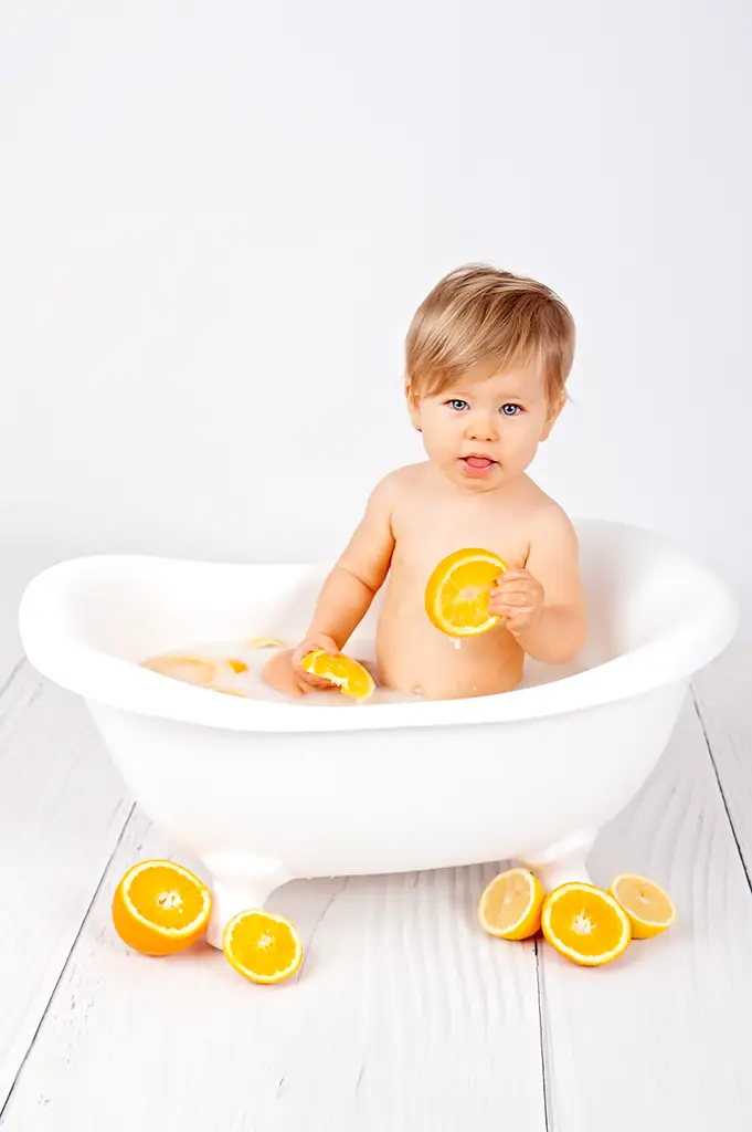 Bébé dans son bain et oranges